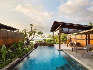 a swimming pool in a villa with a house at Radisson Blu Resort & Villas Bali Uluwatu in Uluwatu