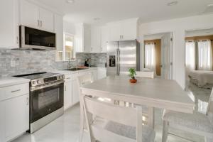 a kitchen with white cabinets and a table with chairs at 13 Mi to Universal Studios: Renovated Cottage! in Los Angeles