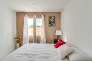 a white bed with a pink pillow in a bedroom at 13 Mi to Universal Studios: Renovated Cottage! in Los Angeles