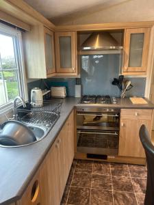 a kitchen with a sink and a stove at OV19- Wind in the willow summer house in Heysham
