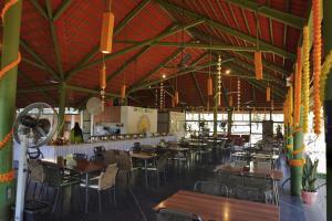a restaurant with tables and chairs in a room at Touchwood Bliss Nature Retreat - Igatpuri in Igatpuri