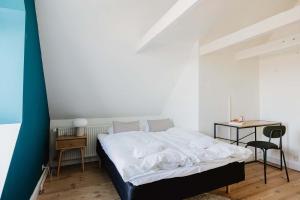 a bedroom with a bed and a table with a chair at Odense Doublex Penthouse in Odense