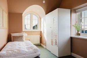a small bedroom with a bed and a window at Odense Doublex Penthouse in Odense