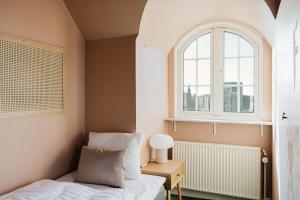a small bedroom with a bed and a window at Odense Doublex Penthouse in Odense