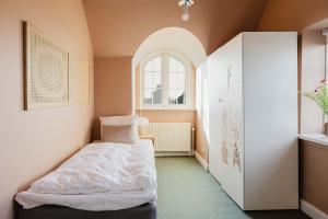 a small room with a bed and a window at Odense Doublex Penthouse in Odense