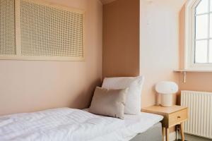 a bedroom with a bed and a table with a lamp at Odense Doublex Penthouse in Odense +44 photos
