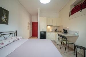 a bedroom with a white bed and a kitchen at Delphian Colors - Red Edition by Filos Inc in Delphi