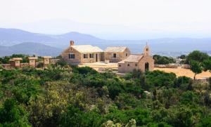 an old building on top of a hill with trees at House Pool House Lake by the sea in Pirovac