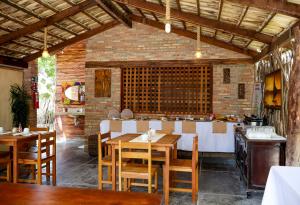 a restaurant with wooden tables and chairs and a bar at Vila Pescador Fortim in Fortim