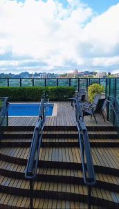 a deck with chairs and a swimming pool on a building at Master Plaza Hotel in Barbacena