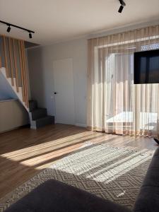 a living room with a large window and a television at Tavo Jūros Namai in Palanga