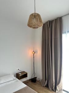 a bedroom with a bed and a lamp and a window at Ambelas Getaways in Himare