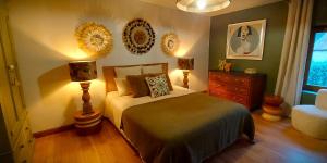 a bedroom with a bed and two lamps and a dresser at Gîte Les Pierres Blondes in Groléjac