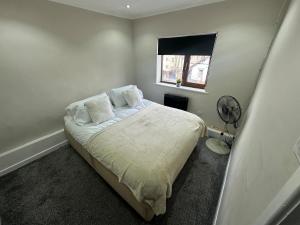 a bedroom with a bed and a window and a fan at Modern 2 Bed Apartment, Sleeps 4 in Bolton