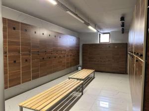 a locker room with a bench and wooden panels at Aquapark Quba Hotel in Quba