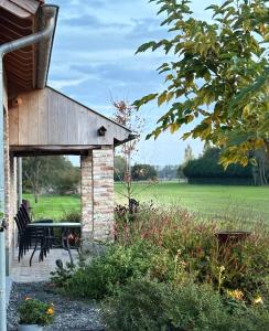 a pavilion with a table and chairs in a garden at Snow&Rose in Damme