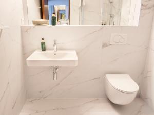 a white bathroom with a sink and a toilet at Hotel Cvilín in Krnov +49 photos