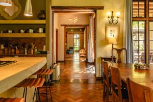 a kitchen with a bar and a table and chairs at The River Villa in Magaliesburg