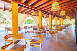 a row of tables and chairs in a restaurant at Palm Beach Resort in Serekunda