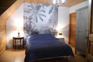 a bedroom with a blue bed with a palm tree mural at Gîte avec jardin pour 6 pers près de Salers Nature & Puy Mary in Le Vigean