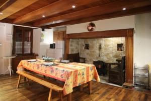 a dining room with a table and a stone fireplace at Gîte avec jardin pour 6 pers près de Salers Nature & Puy Mary in Le Vigean