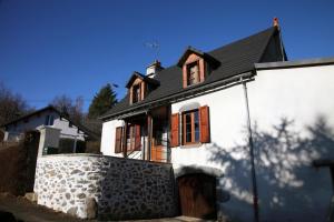 a white house with a black roof at Gîte avec jardin pour 6 pers près de Salers Nature & Puy Mary in Le Vigean