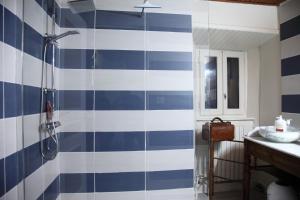 a bathroom with a blue and white striped wall at Gîte avec jardin pour 6 pers près de Salers Nature & Puy Mary in Le Vigean +10 photos