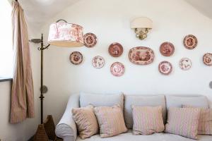 a living room with a couch and plates on the wall at Eremo della Maddalena the oasis of the 5Terre in Monterosso al Mare +76 photos