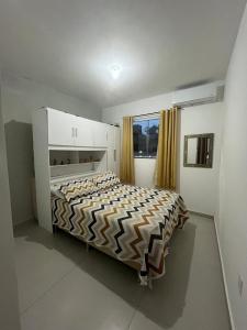 a bedroom with a bed in a room with a window at Casa de Praia no Condomínio Florestinha com 02 quartos in Tamoios +7 photos