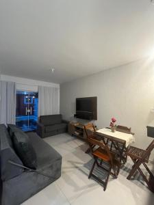 a living room with a couch and a table at Casa de Praia no Condomínio Florestinha com 02 quartos in Tamoios