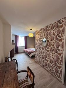 a living room with a table and a bed at Le Verger in La Charmée