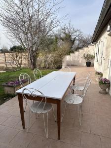 a wooden table and chairs on a patio at Le Verger in La Charmée