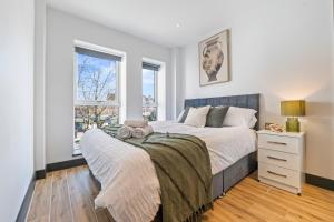 a bedroom with a large bed and a window at Modern 2-Bed Apartment 30 mins from Central London in Finchley
