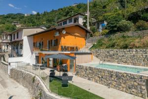 a house with a swimming pool next to a wall at Casa Santari in Parzanica