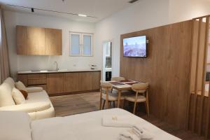 a living room with a white couch and a kitchen at Zoe Boutique Hotel in Durrës