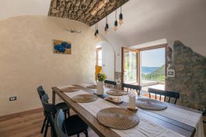 a dining room with a wooden table and a large window at Casa Santari in Parzanica
