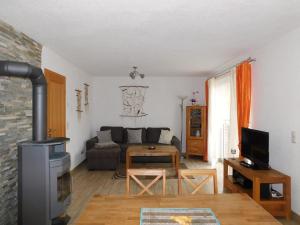 a living room with a couch and a stove at Hus an de Küst 02 in Ahrenshoop
