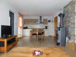 a living room with a table and a kitchen at Hus an de Küst 02 in Ahrenshoop