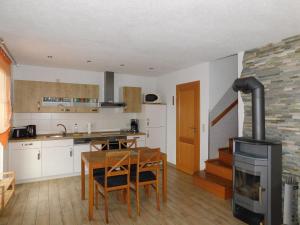 a kitchen with a table and a wood stove at Hus an de Küst 02 in Ahrenshoop