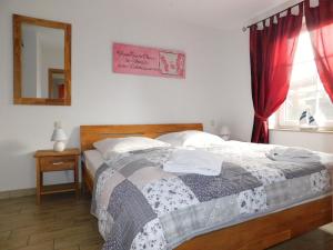 a bedroom with a bed and a mirror and a window at Hus an de Küst 02 in Ahrenshoop +3 photos