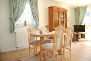 a dining room with a wooden table and chairs at Boddenhus in Born