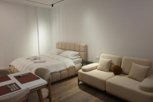 a bedroom with a bed and a couch and a table at Zoe Boutique Hotel in Durrës