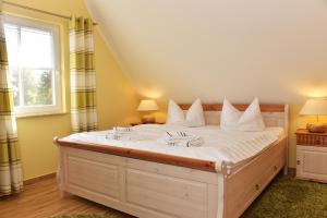 a bedroom with a large bed with white sheets at Boddenkieker in Born