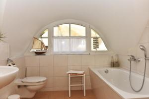 a bathroom with a tub and a toilet and a sink at Boddenkieker in Born +8 photos