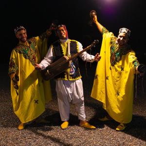 three men dressed in costumes posing for a picture at Be Nomad Agafay Camp in El Karia