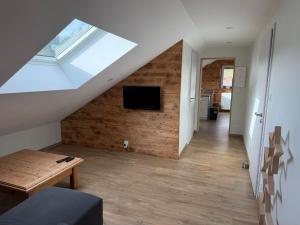 a living room with a skylight and a wooden wall at Gîte au pied du Mont in Saint-Maurice-sur-Moselle