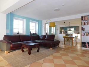 a living room with a brown couch and a table at Ferienhaus La Mer in Ahrenshoop
