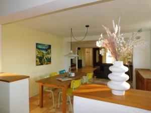 a dining room and living room with a vase on a table at Ferienhaus La Mer in Ahrenshoop