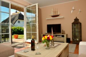 a living room with a table with flowers and wine glasses at Schipperhus in Born +4 photos