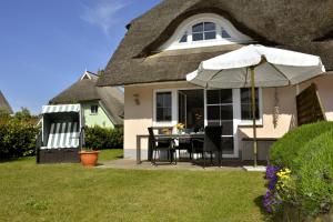 a house with a table and an umbrella in the yard at Schipperhus in Born
